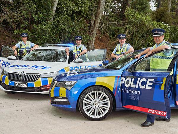 Road safety staff standing beside their police cars