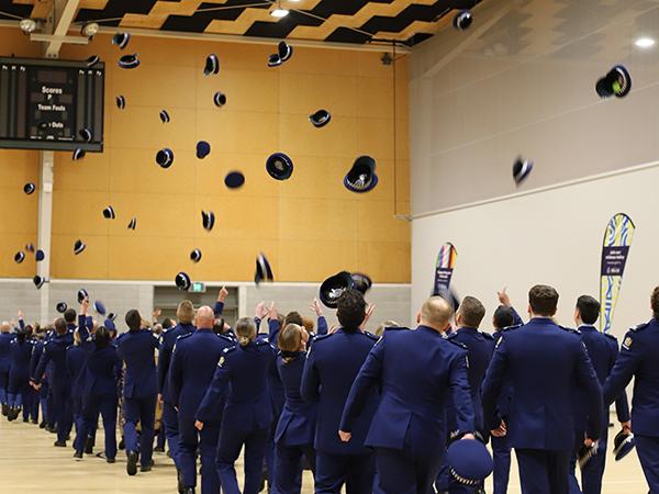 Wing 378 throwing their hats in the air at their graduation after parade dismissed. 