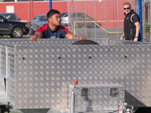 Hurricane Danny Toala is all determination as he pushes the trailer, watched by Magpies trainer Josh Syms.