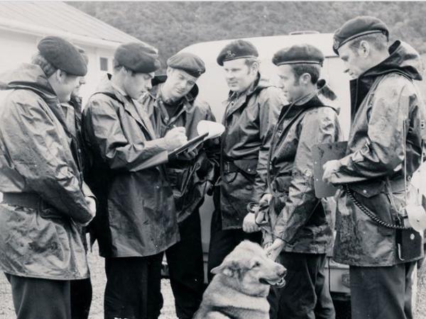 AOS Commander Bernie, with clipboard, briefs staff including Tom Penrose, seen second from right with his dog Ochre.