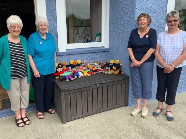 Pam (wearing the navy top) and some members of her knitting circle with their bevy of care bears.