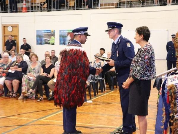 Constable Tane Tuhakaraina receives his award from Commissioner Andrew Coster while Police Minister Hon Poto Williams looks on.