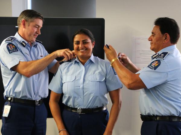 Senior Sergeant Mandeep Kaur receives her epaulettes from Commissioner Andrew Coster and Deputy Commissioner Wally Haumaha.
