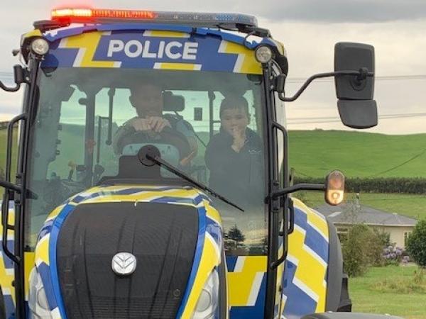 Sergeant Blair Wilkinson driving Reid to school in the tractor. 