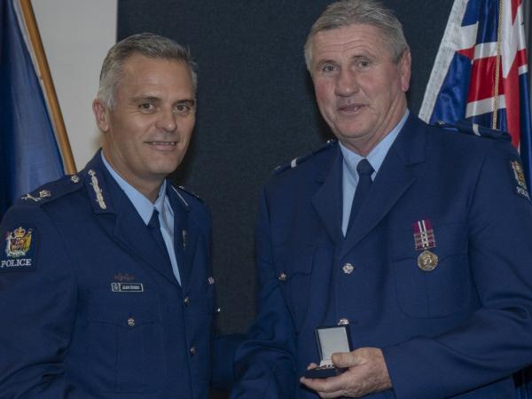 Senior Constable Shane Gibson receiving his 42-year medal from Deputy Commissioner Glenn Dunbier in July 2020.