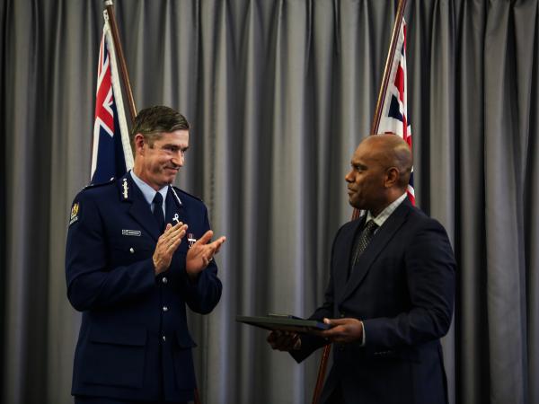 Commissioner Andrew Coster applauding Detective Inspector Uraia Vakaruru after presenting his Police Meritorius Service Medal.