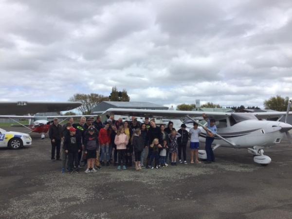 A group photo next to one of the planes.