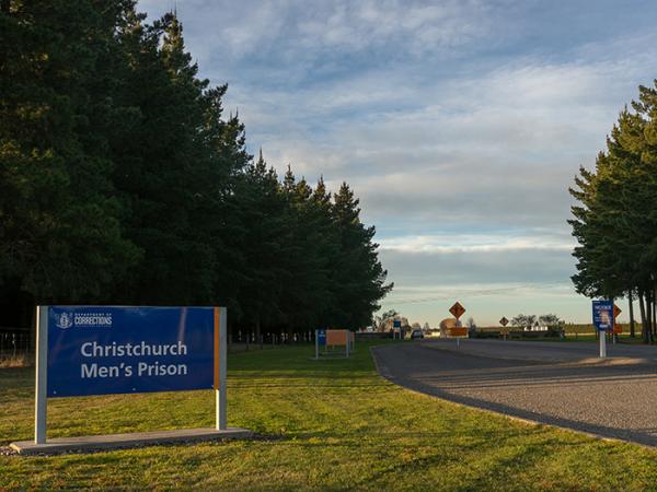 A sign saying Christchurch Men's Prison at the entrance of the driveway to the prison. 