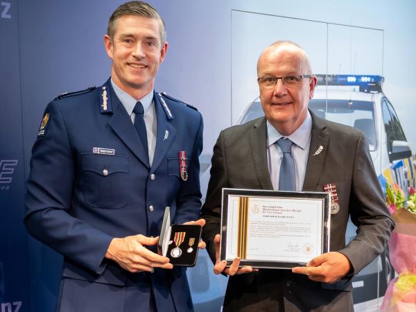 Commissioner Andrew Coster presents Olaf Jensen with his MSM.