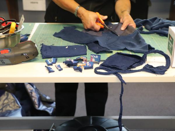 Old police jumpers being processed by TIMG in Wellington where all the non-woollen parts of the jersey are removed. 