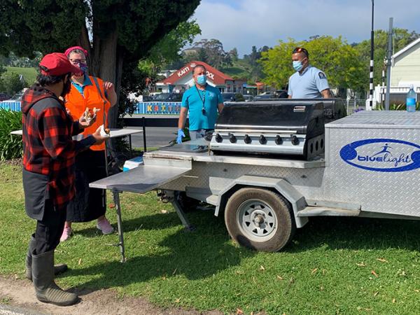 Constable Rangitawhiao Kingi helps Te Aka Ora staff on the BBQ at the clinic. 