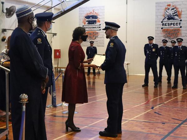 Minister Williams gives Constable Lewis Ferguson his certificate for achieving top of the wing.