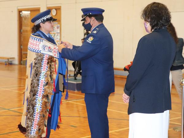 Minister's Award winner Constable Jess Courtney receives the RNZPC korowai from Deputy Commissioner Haumaha.