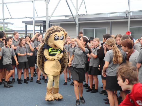 Blue Light mascot Harry the Hedgehog (Māori Warden Sharnee Miller) gets down to the beat with a Feilding Intermediate School stu