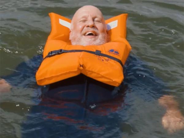 Officer floating in the water with a lifejacket on. 