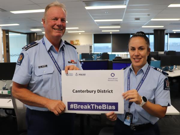 A male officer and a female officer in Canterbury District holding up a #BreakTheBias sign.