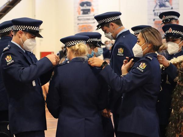 Some of the new constables helping each other change their epaulettes.