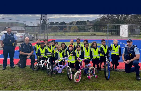 L-R: Constable Josh Edwards, Senior Constable Jason Page, happy Upokongaro school kids with the bikes and Sergeant Peta Pehi.