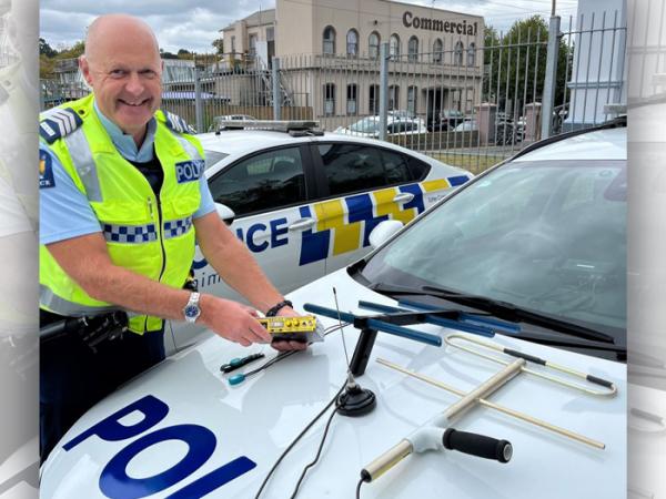 Whanganui Sergeant Colin Wright next to a police car with the WanderSearch technology on the bonnet.