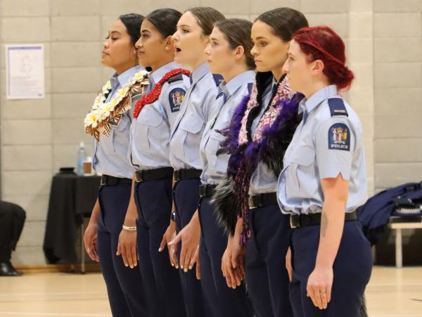 Six women from the wing giving the kaikaranga.