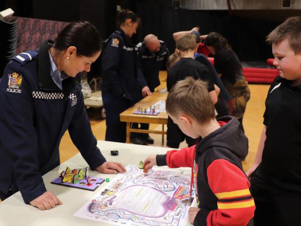 Senior Constable Rosie Marchant takes some keen young players through the road safety board game she created at Gore's 'Clued Up