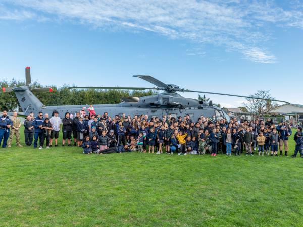 Group photo in front of the Air Force helicopter that landed on the school field.
