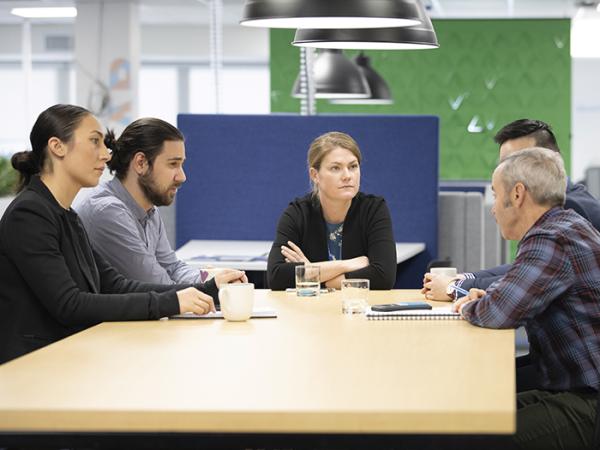Stock shot of people sitting around a table in discussion. 
