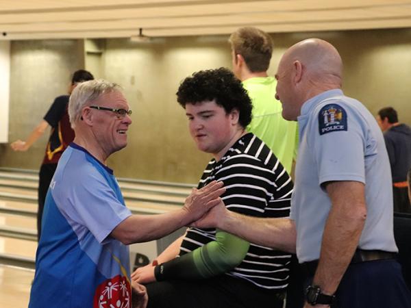 Senior Constable Stu Blake high-fives a fellow bowler.