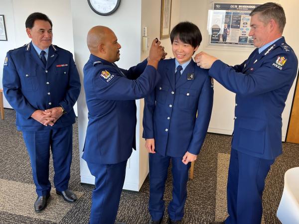 Senior Sergeant Steve Smith (RNZPC) and Commissioner Coster places constable epaulettes on Polly’s shoulders while Deputy Commis