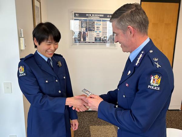 Constable Polly Yeh shaking hands with Commissioner of Police Andrew Coster as he hands her her constable epaulettes. 