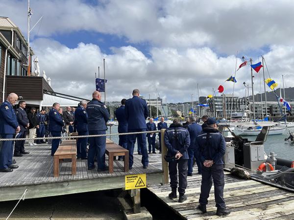 Photo of 20-30 staff gathered outside by the Hukatai vessel as it is blessed.