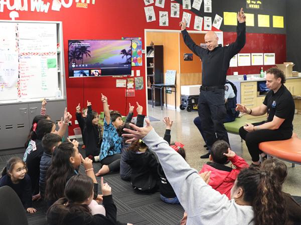 Ben, Jason, and Peta talking with the tamariki about being a police officer.