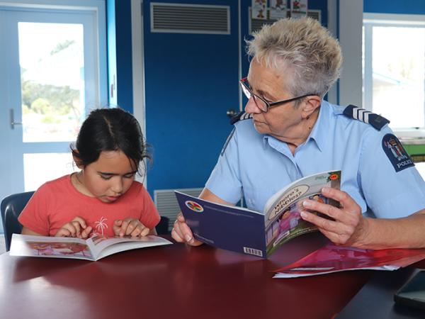 Sergeant Cath Jones reading with Olive at Te Wharau School.
