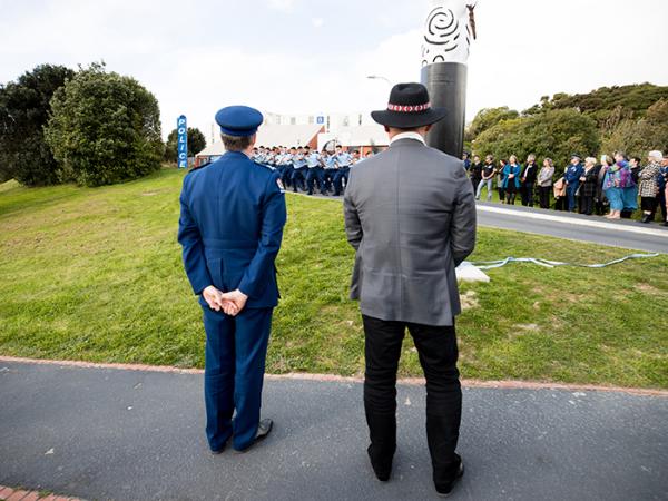 Photot taken from behind of Callum Katene Commissioner Andrew Coster watching members of Wing 359 perform the haka. 