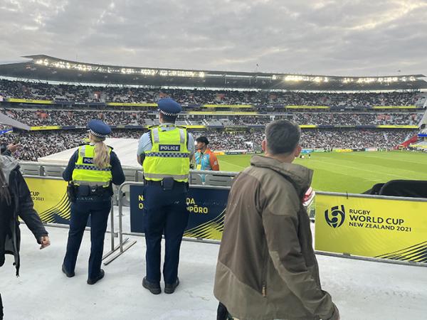 Shot from behind of Constables Hannah Green and Eddie Aufai looking out over the history-making crowd at Eden Park.