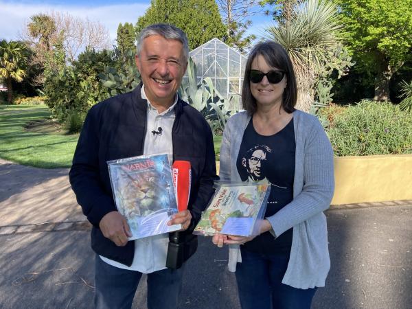 Jill White and Michael Holland holding some of the children's books Jill hides for children to find. 