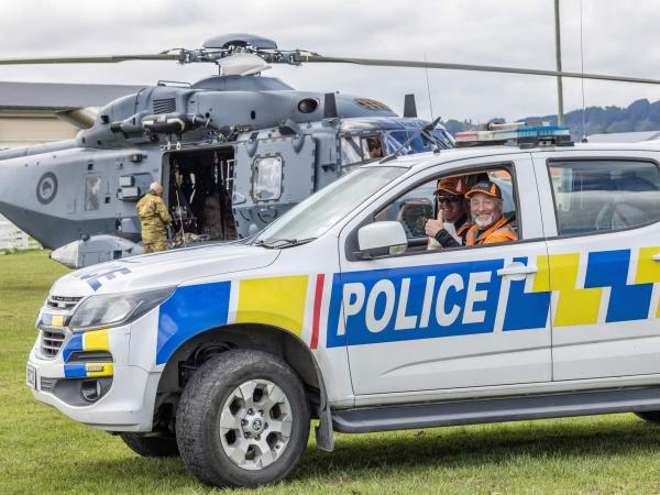Constable Ben Luders and LandSAR volunteer Carl Knight with an NH90 in the background. Photo credit: Louise Knight.