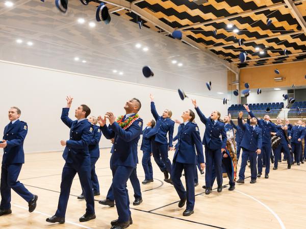 The new constables throwing their hats in the air after their graduation.