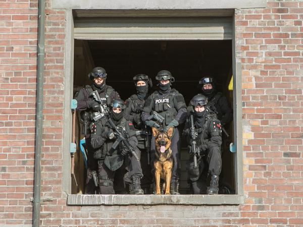 Gill in front of handler Tim and Timaru AOS colleagues in the 2017 Police Dog Trust Calendar. Photo: Constable Aaron Collins.