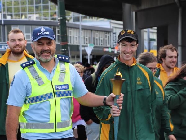 Insp Bennett holding the flame of hope torch with one of the athletes.