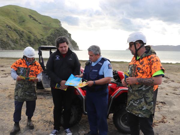 Senior Sergeant Maui Aben and Terence Maru from Rongomaiwahine Iwi Trust discuss the new quad bike brochure with two of the iwi'