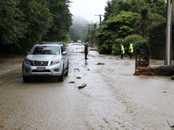 Local FENZ and Police survey the extent of the water damage along a portion of Valley Road in Gisborne.