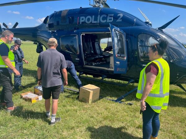 Loading food packs onto the Police Eagle helicopter at Gisborne Airport.