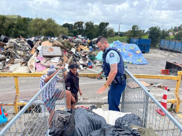 Volunteers and Sergeant Sean Burn clearing rubbish at King House Church, Maraenui.