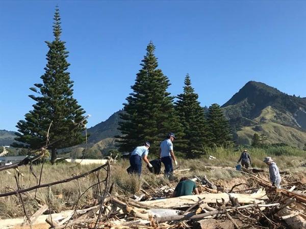 Police staff helping with a beach clean-up.