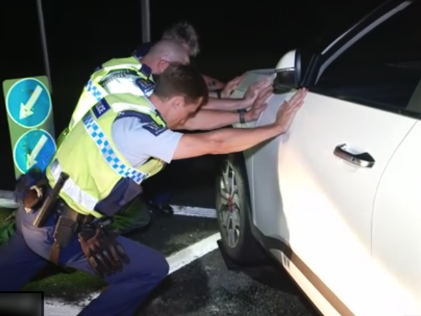 Two officers pushing the vehicle out of the way. 