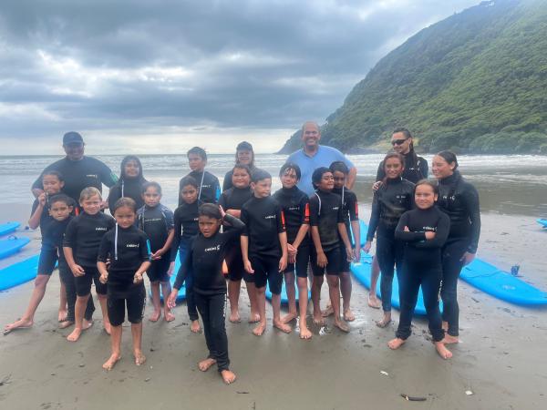 Constables Abi Daunton and Senior Constable Justin Moore (both middle back) with the young surfers and helpers.
