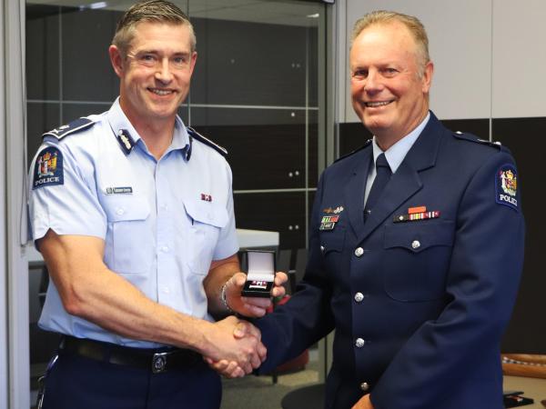 Commissioner Andrew Coster presents John with his 35-year clasp at a farewell ceremony at PNHQ.