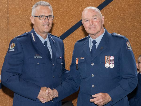 Congratulations from Deputy Commissioner Glenn Dunbier as Mark receives his 49-year Long Service and Good Conduct award.