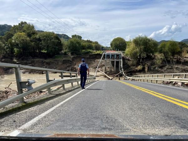 Sergeant Ben Joll assesses the damage to the collapsed Hikuwai Bridge on State Highway 35 near Anaura Bay north of Gisborne.